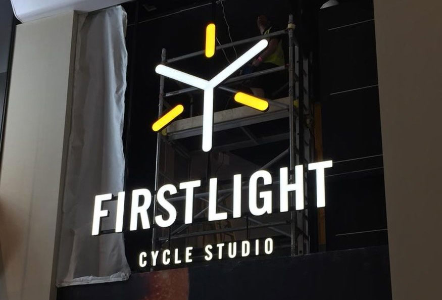 First Light Cycle Studio illuminated suspended sign